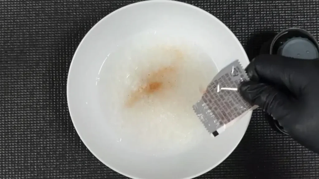 완성된 비상식량 죽에 소금을 추가하여 전해질과 맛을 보충하는 모습