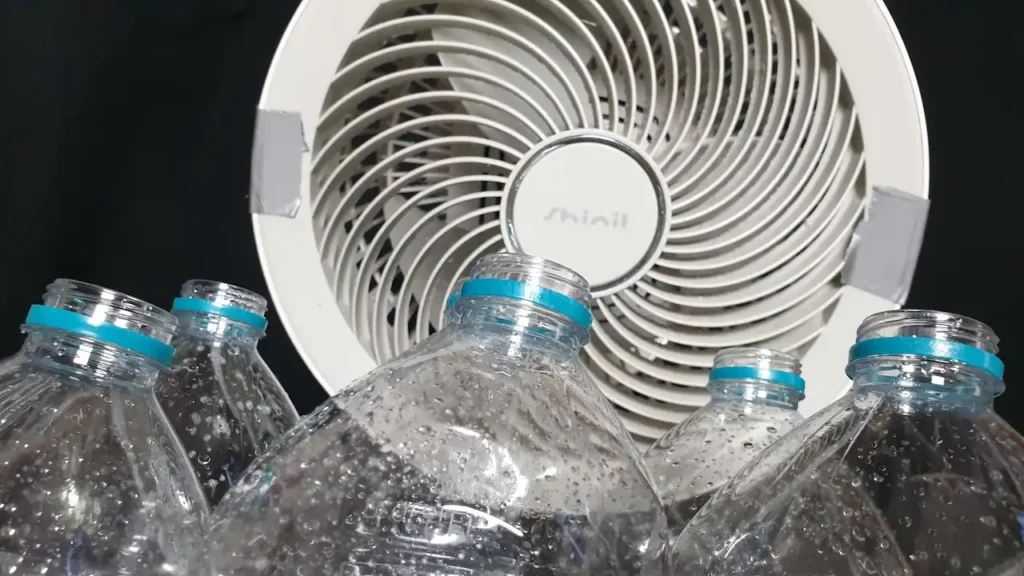 비상식량 보관 전 내부 물기를 제거하기 위해 거꾸로 세워진 페트병들. 선풍기를 활용한 강제 건조 방식을 시각적으로 보여주는 모습