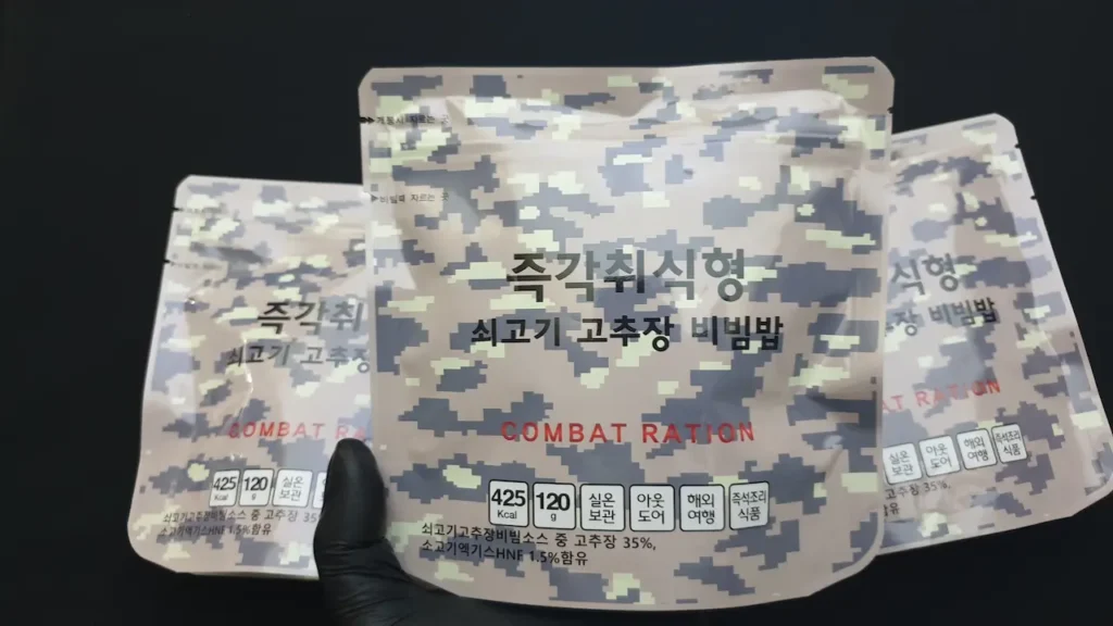 디지털 카모플라주 패턴 패키지의 한국 즉각취식형 참맛 전투식량 쇠고기 고추장 비빔밥 3팩이 나열된 모습